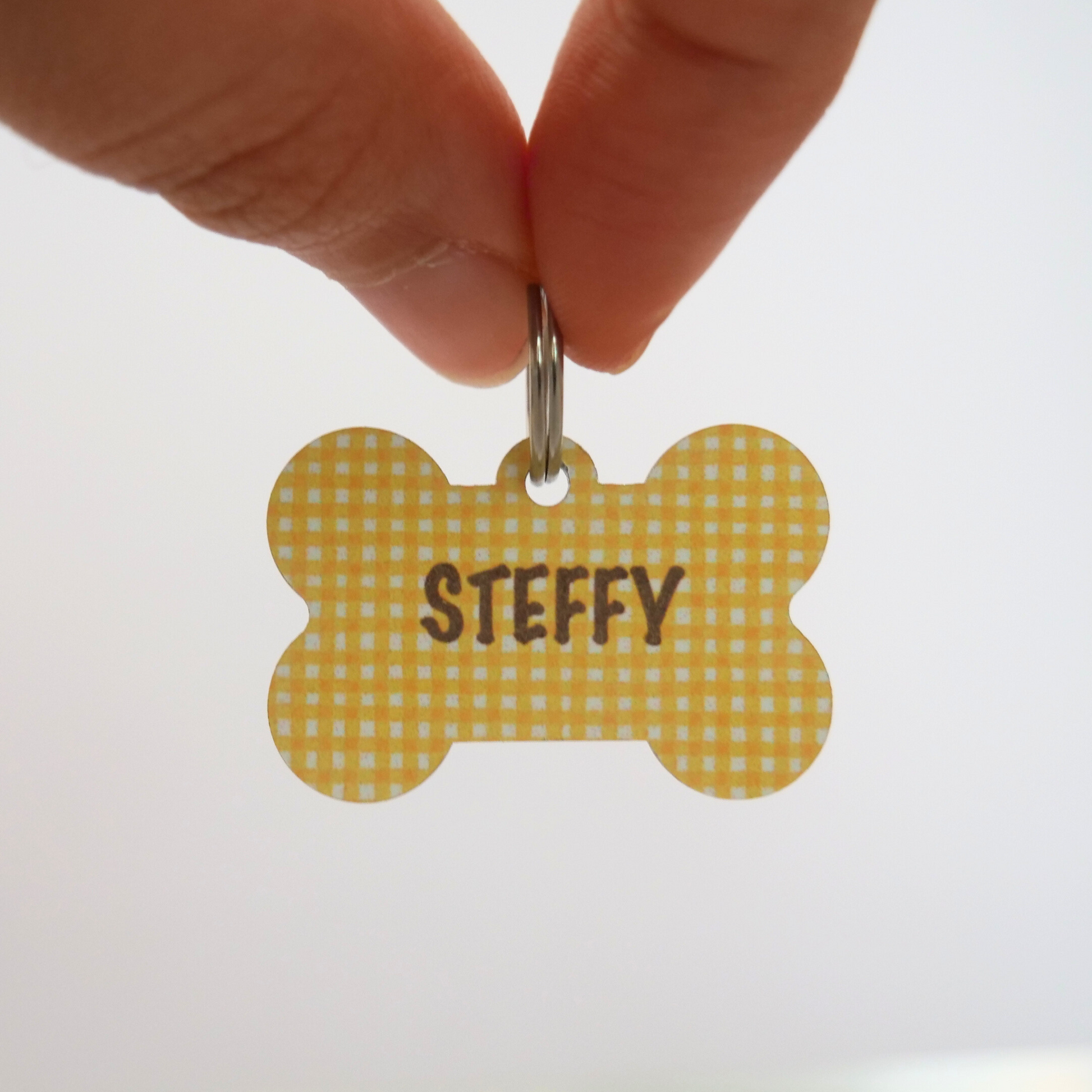 Chapa identificativa amarilla vichy para perros de la marca My Pet Atelier, con información visible en la imagen