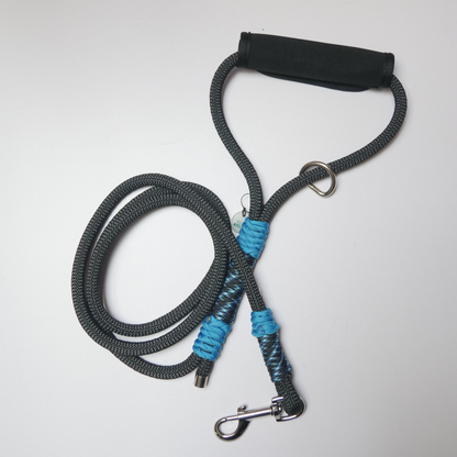Correa de paseo para perro en color negro y azul turquesa, con asa resistente y ajustable, ideal para paseos seguros y cómodos.